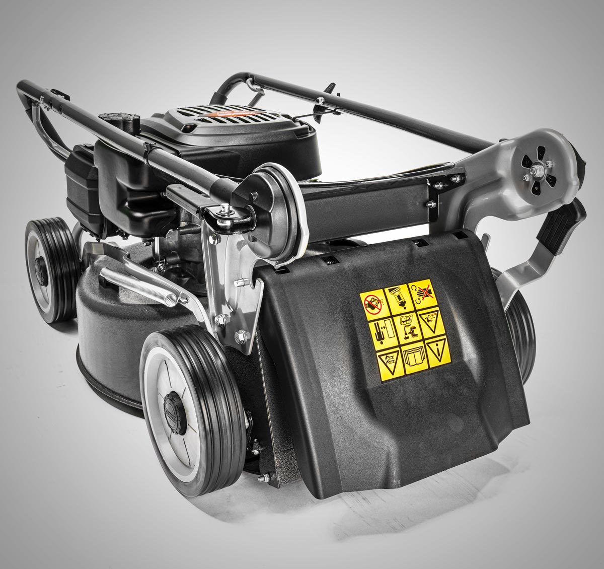 A black and silver cordless lawn mower with a black plastic deck cover, yellow warning labels, and a black handle, shown on a light gray background.