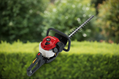 A Honda hedge trimmer with a red engine cover, white gas tank, and black handle, shown on a clean white background.