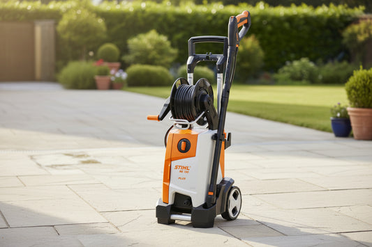 A STIHL high-pressure washer with an orange and white body, black hose reel, and black handle, shown on a plain white background.