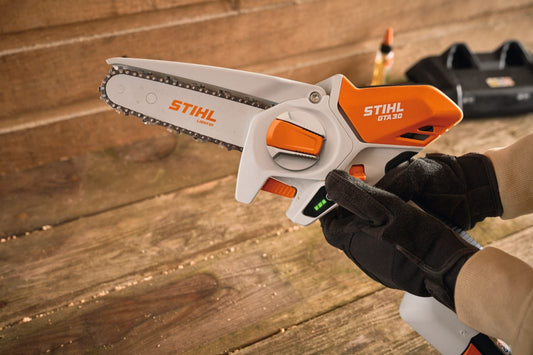 Stihl power tool held by a person on a wooden surface